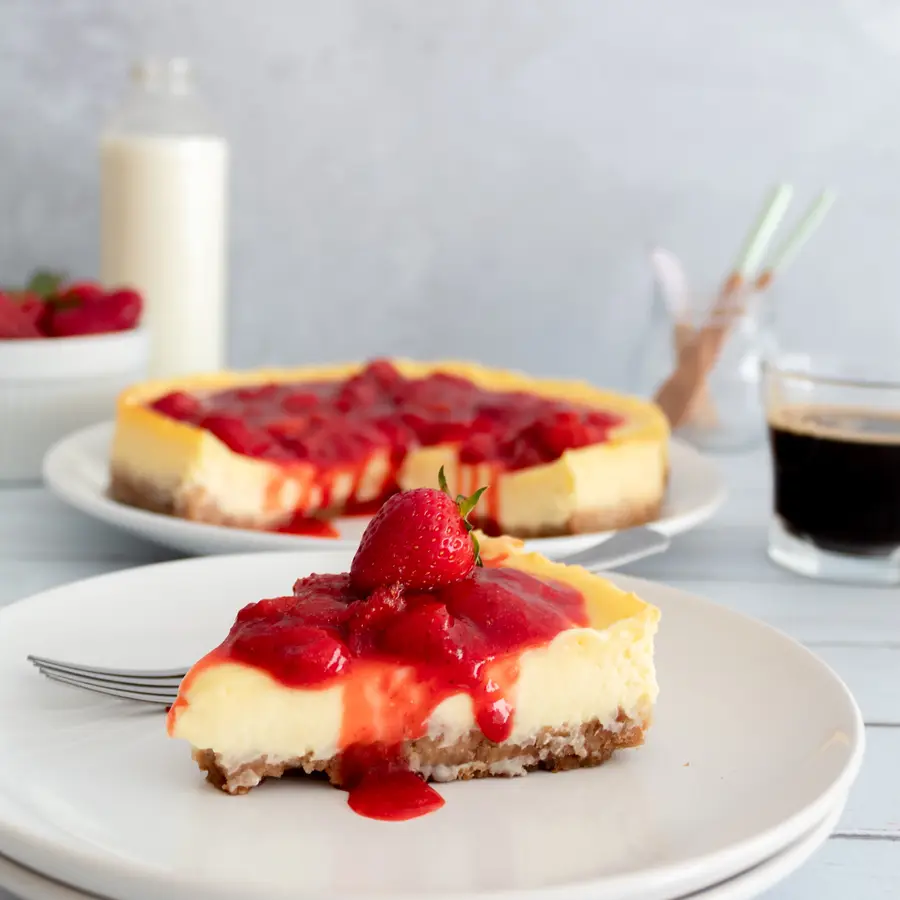 Cheesecake con salsa de frutilla servido en plato