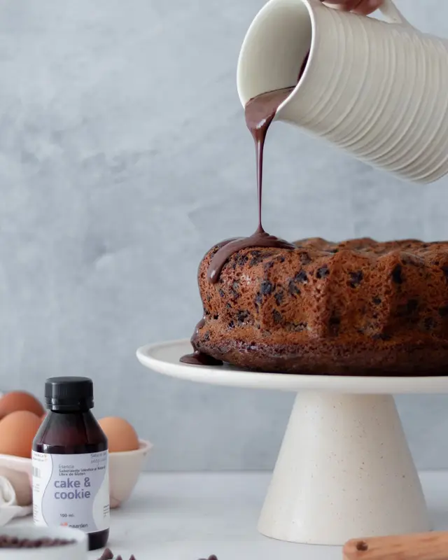 Bundt cake de chocolate con ganache cayendo desde una jarra