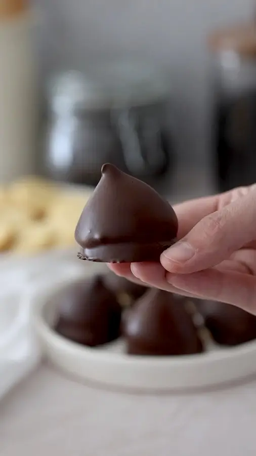 Video: manos bañando conitos de dulce de leche en chocolate
